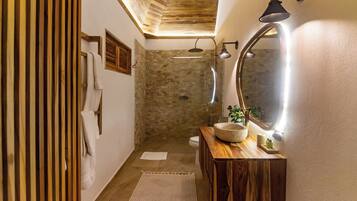A bathroom with a wooden vanity, a large mirror, and a shower area.