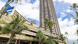 A high-rise building with multiple balconies and palm trees in the foreground. - Cozy condo at Hawaiian monarch- no resort fee, free parking, near beaches, shop (Honolulu)