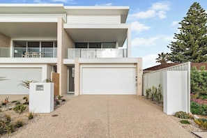 A modern two-story house with a garage, a balcony, and a well-maintained garden. - Driftwood Port Noarlunga South (Port Noarlunga South)