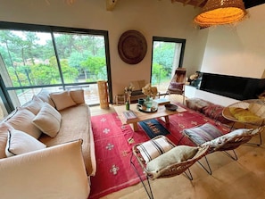 A spacious living room with a sofa, chairs, a coffee table, and a fireplace. - Amazing high standard Cap Ferret Style Villa A0326 (Lège-Cap-Ferret)