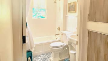 A bathroom with a bathtub, toilet, and sink.