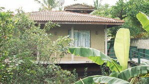 A house with a tiled roof, a satellite dish, and a window with a curtain. - Mass Eco Cabana Yoga & Spa - Unawatuna (Unawatuna)
