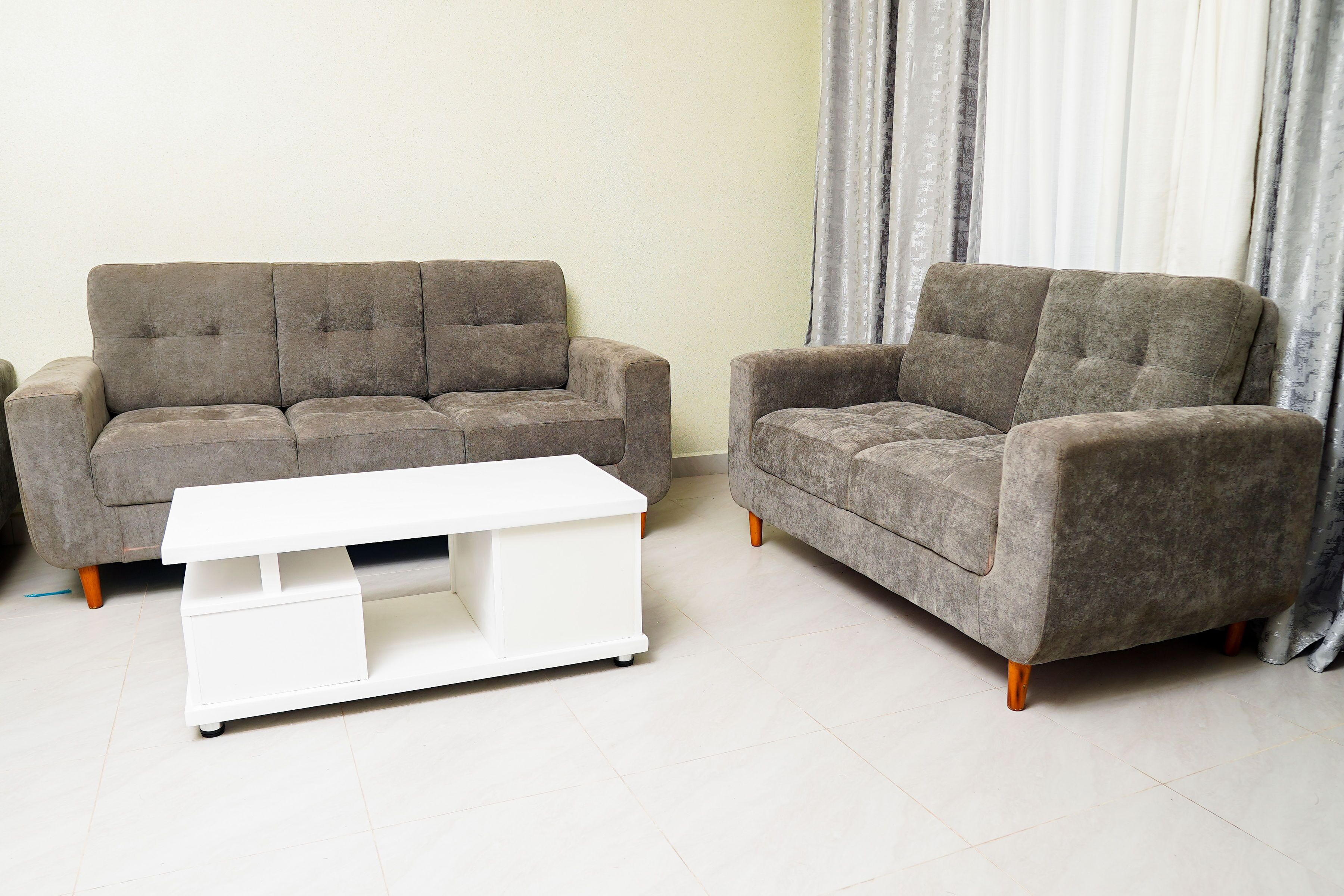 Ein Wohnzimmer mit zwei grauen Sofas und einem weißen Couchtisch.