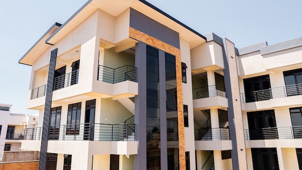Un edificio de varios pisos con balcones, grandes ventanales y un diseño arquitectónico moderno.