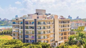 A multi-story residential building with balconies, a central staircase, and a view of the sea. - Lux Suites Palm Terraces Apartments  (Mombasa)