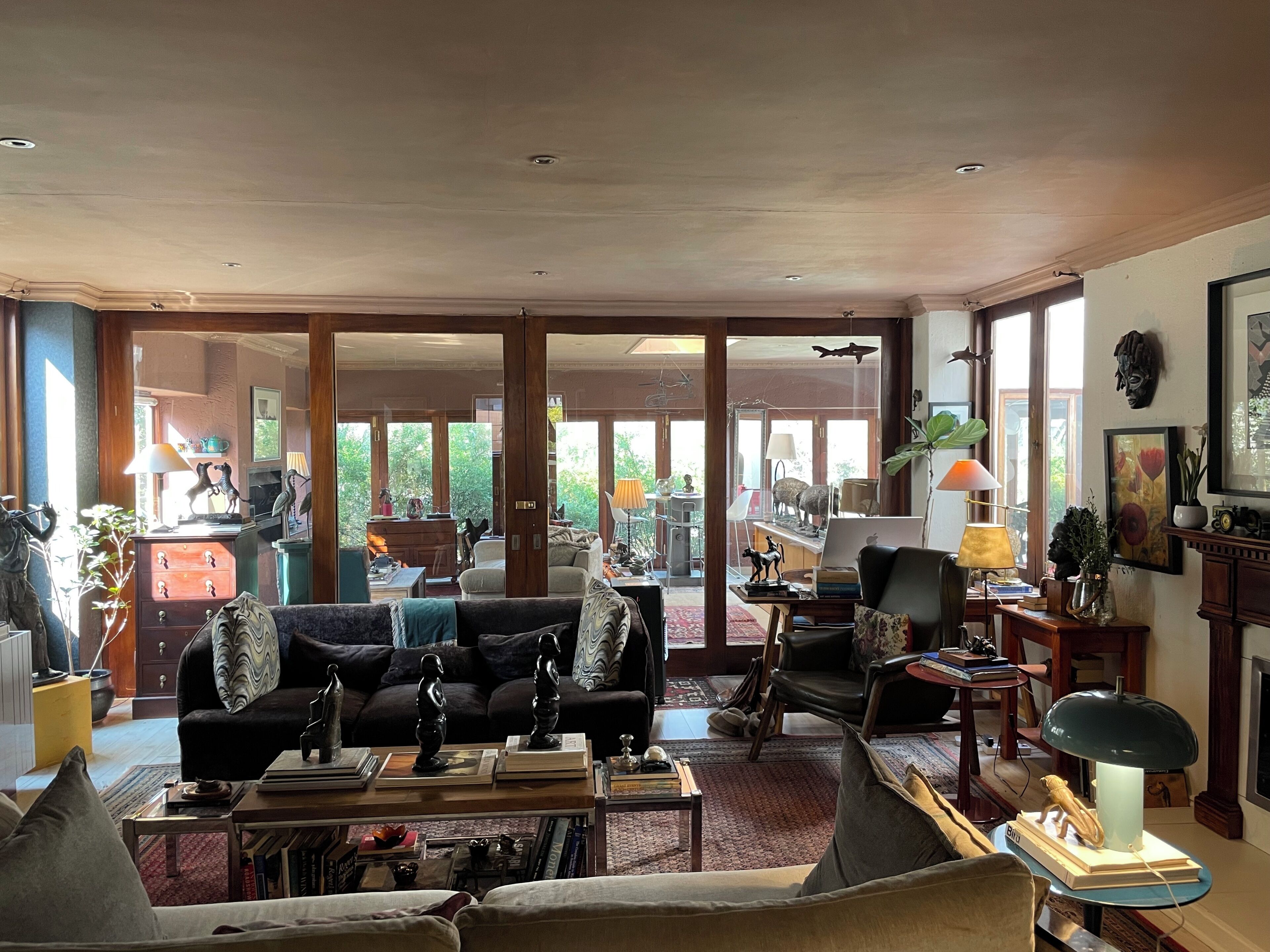 A spacious living room with a large sofa, a coffee table, and a dining area with a table and chairs.