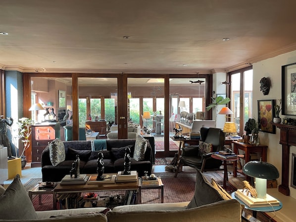 A spacious living room with a large sofa, a coffee table, and a dining area with a table and chairs.