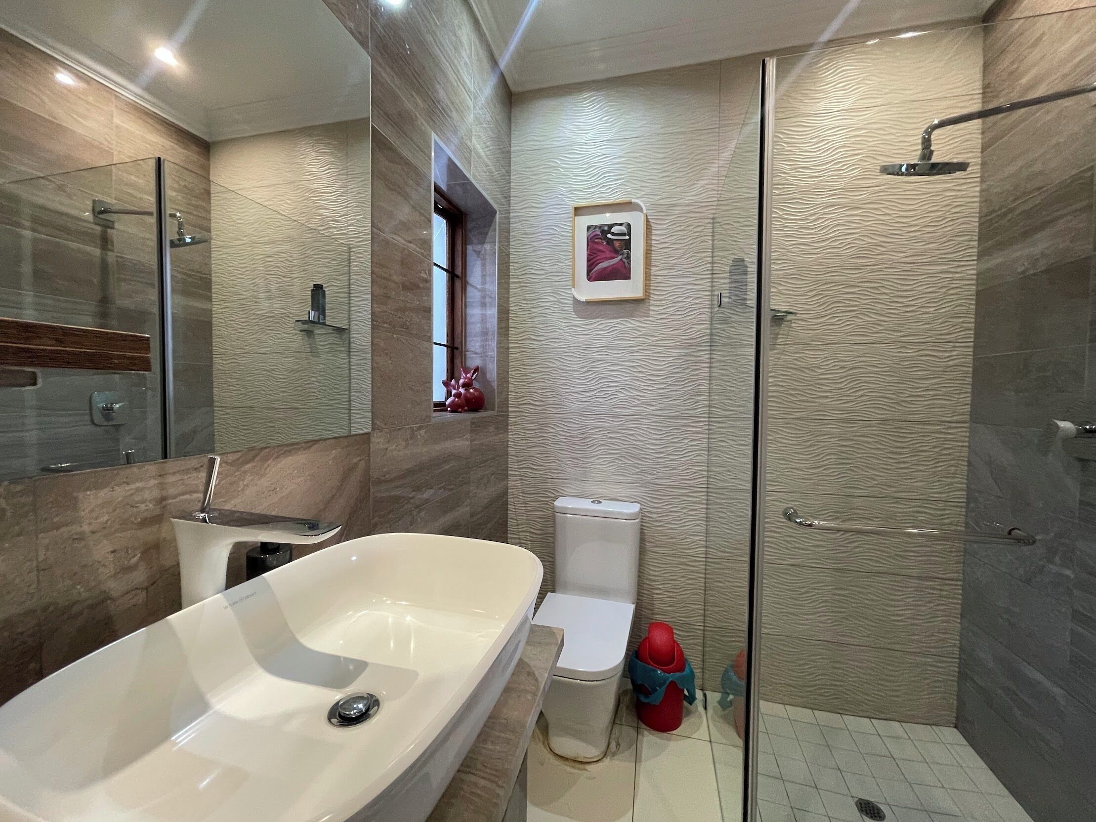 A modern bathroom with a freestanding bathtub, a toilet, and a glass-enclosed shower area.