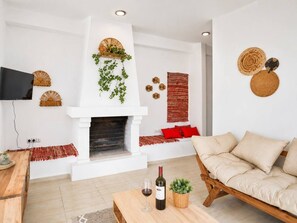 A living room with a fireplace, a sofa, a coffee table, and a television.