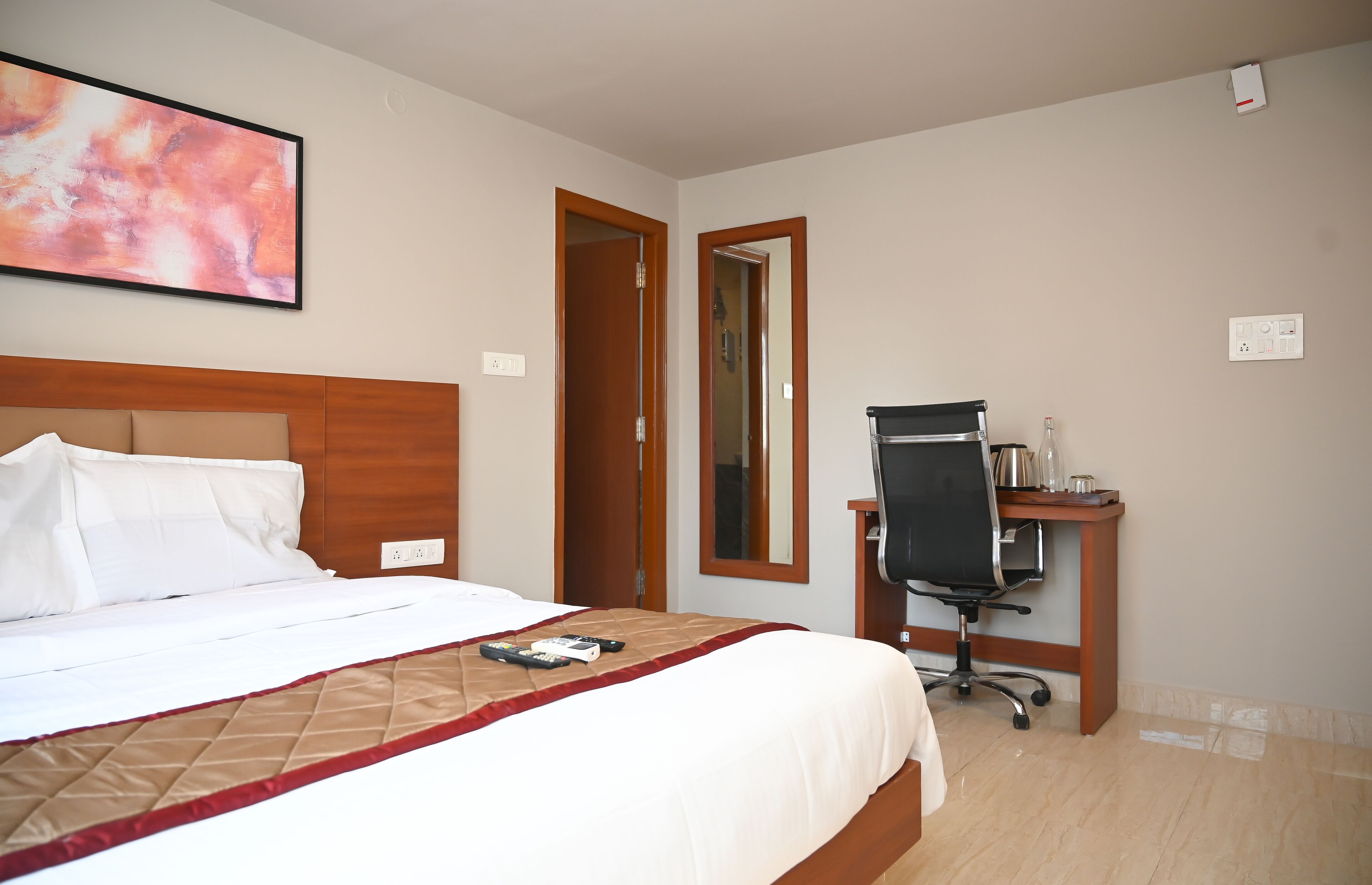 Une chambre d’hôtel avec un lit, un bureau et une chaise.