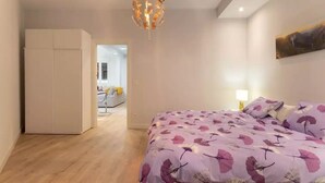 Una camera da letto con un letto, un armadio e un quadro appeso al muro.