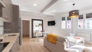 Un appartamento moderno con cucina, zona pranzo e soggiorno.