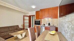 A compact living space with a kitchenette, a dining area, and a sofa. - Apartments Boreta Becici (Becici)