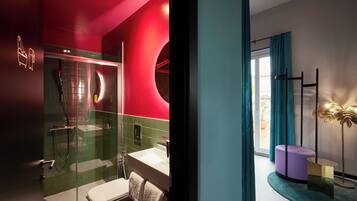A modern bathroom with a glass-enclosed shower, a white sink, and a toilet.