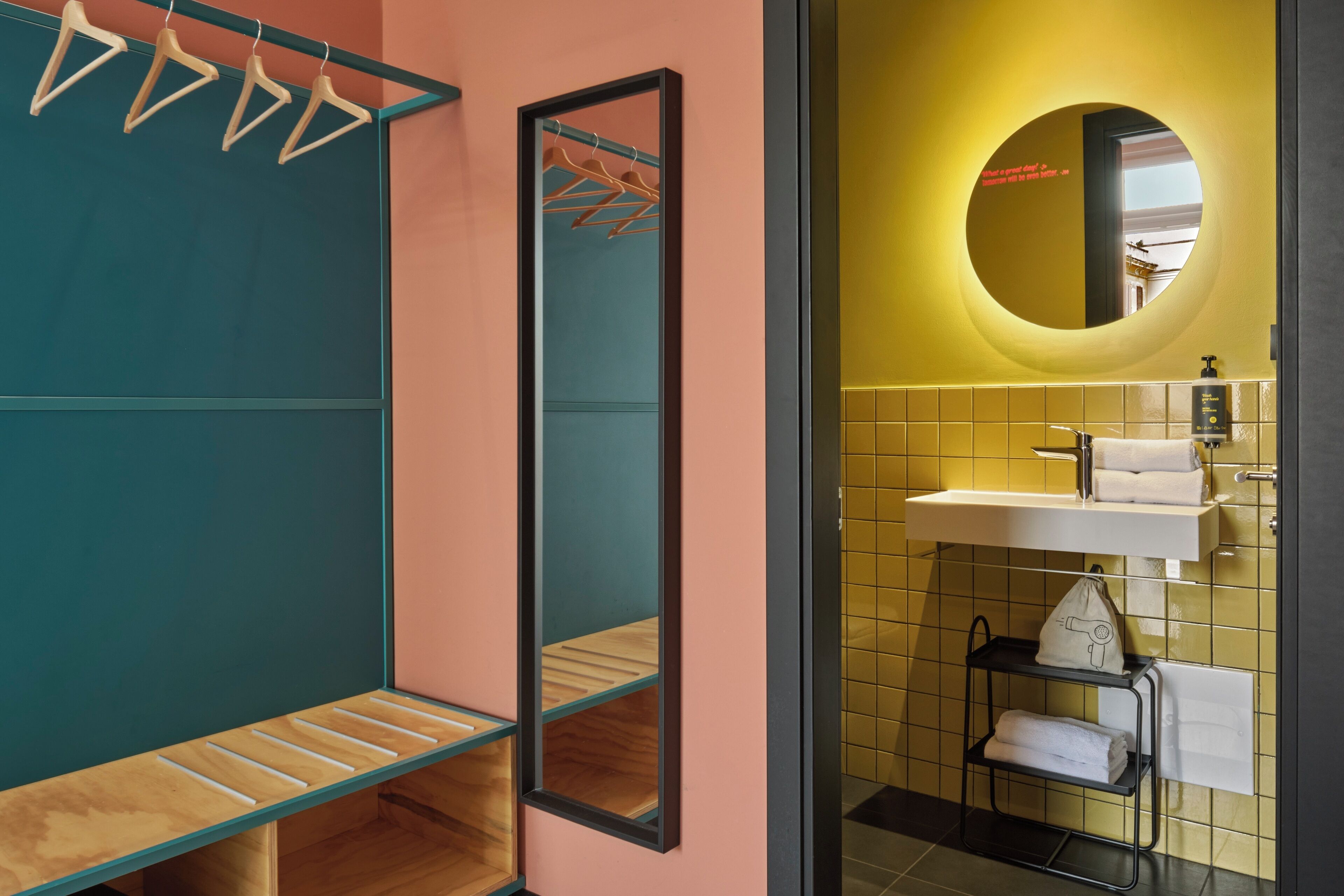 A bathroom with a mirror, sink, and towel rack.