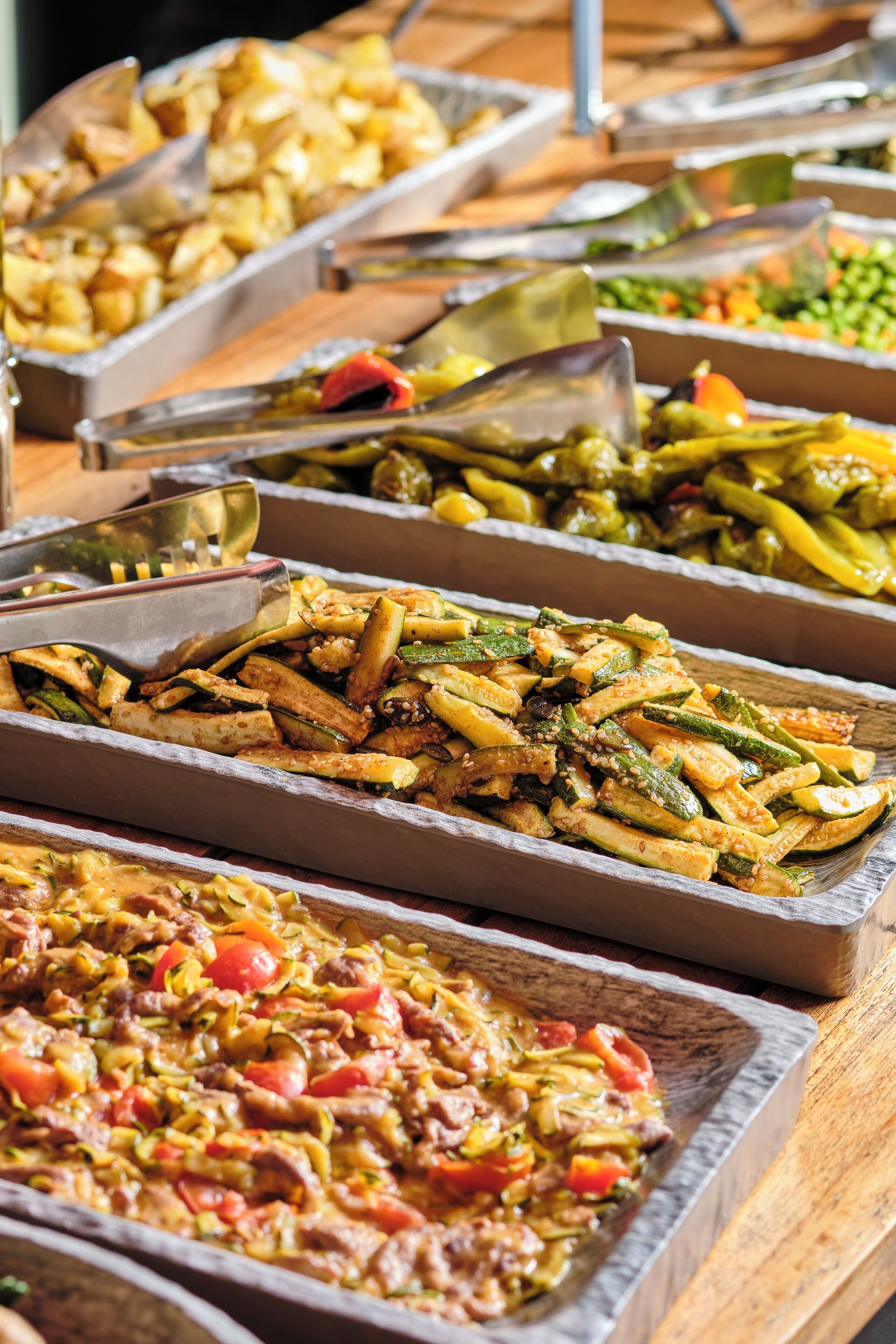 A buffet with various dishes including vegetables, meats, and rice.