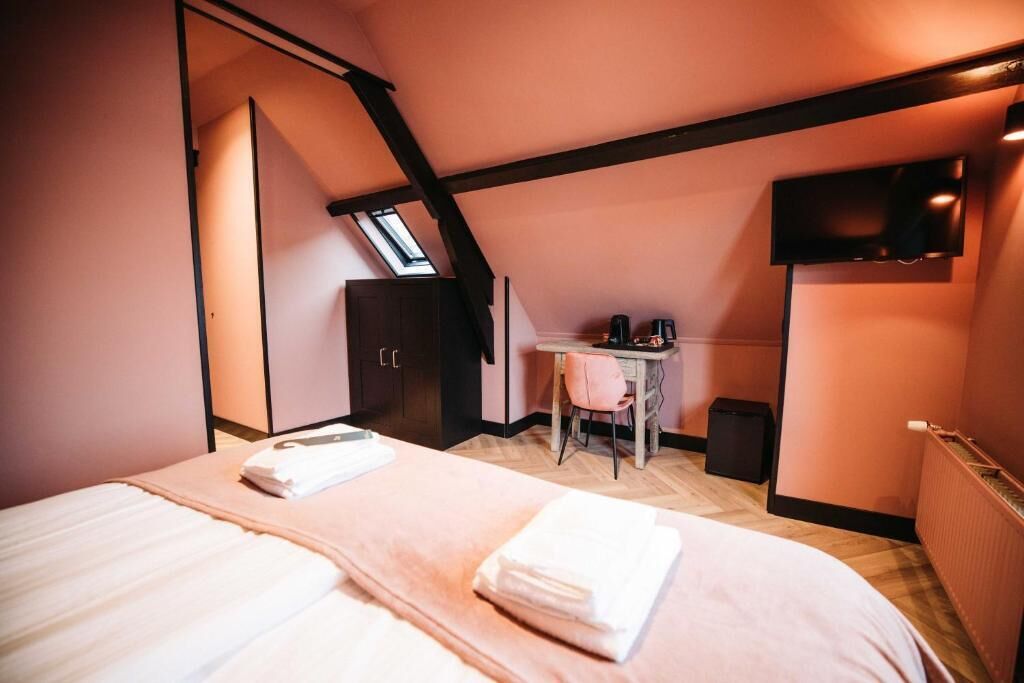 Une chambre à coucher comprenant un lit, un bureau, une chaise, une télévision et une armoire.