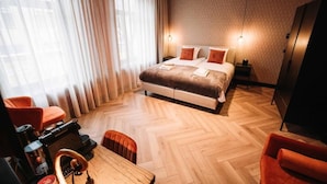 A hotel room with a large bed, a desk with a coffee machine, and a TV. - Boutique Hotel Lupo  (Vlissingen)