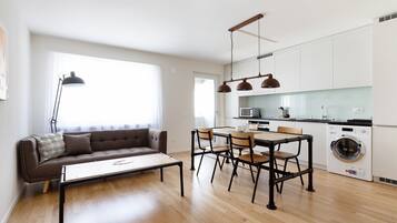 شقة في المدينة | منطقة المعيشة | تلفزيون بشاشة مسطحة بحجم 50-سم يعرض قنوات تلفزيونية رقمية