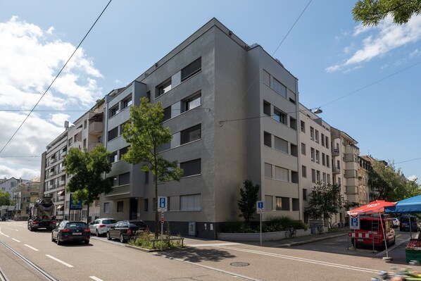 Een meerlaags gebouw met moderne architectuur, voorzien van balkons en grote ramen.