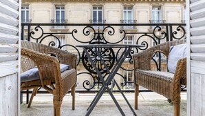 A balcony with wicker furniture and a wrought iron table. - Avenue Heights, by Veeve (Paris)