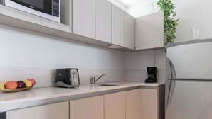 Eine moderne Küche mit Mikrowelle, Toaster, Spüle und Kaffeemaschine.