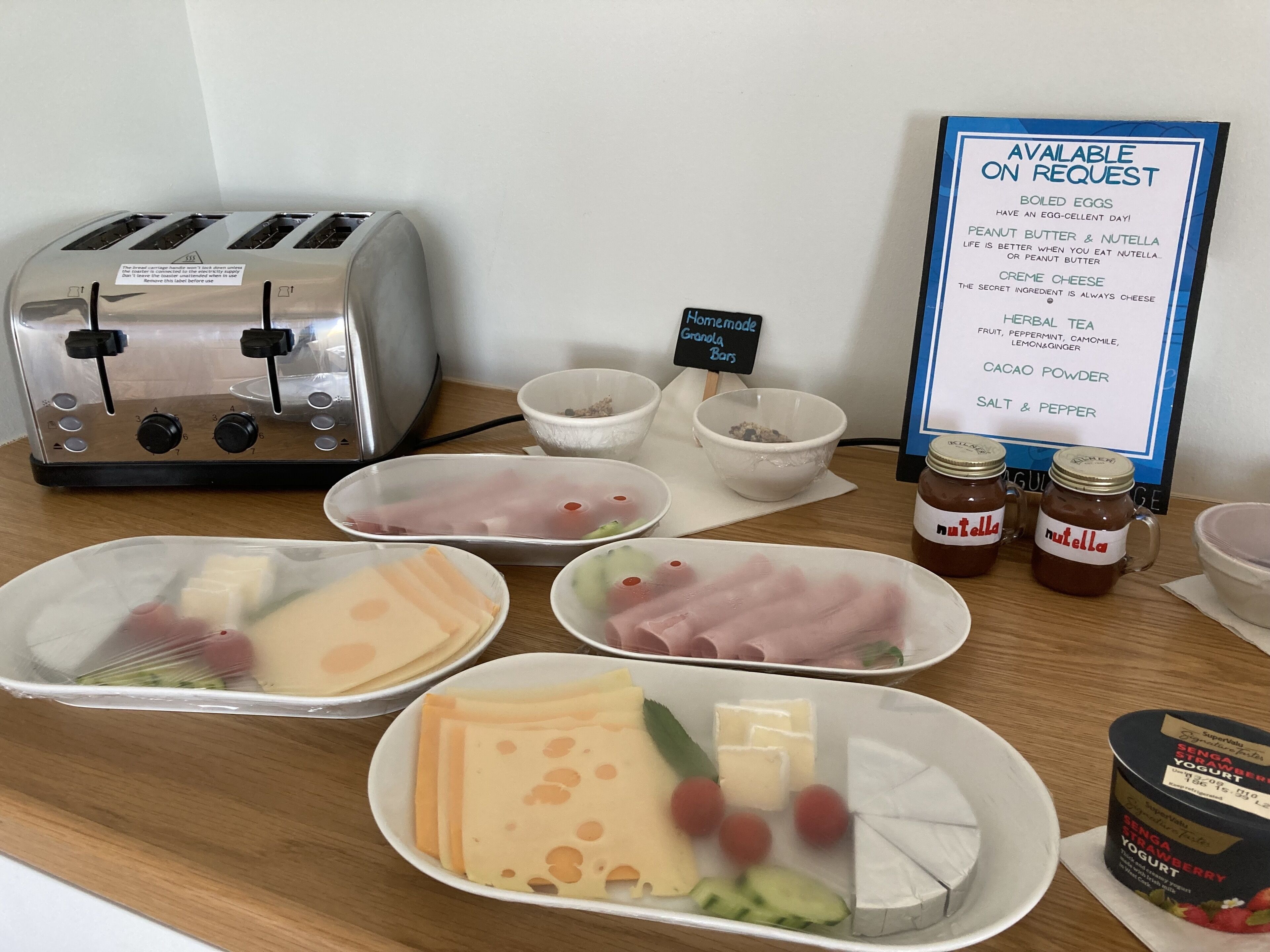 A breakfast setup with various food items and condiments on a table.