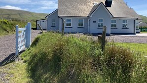 A white building with a grey roof, a chimney, and a sign reading "Glenfiddich".