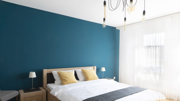 Un dormitorio moderno con una cama de madera, dos mesitas de noche y un tocador.