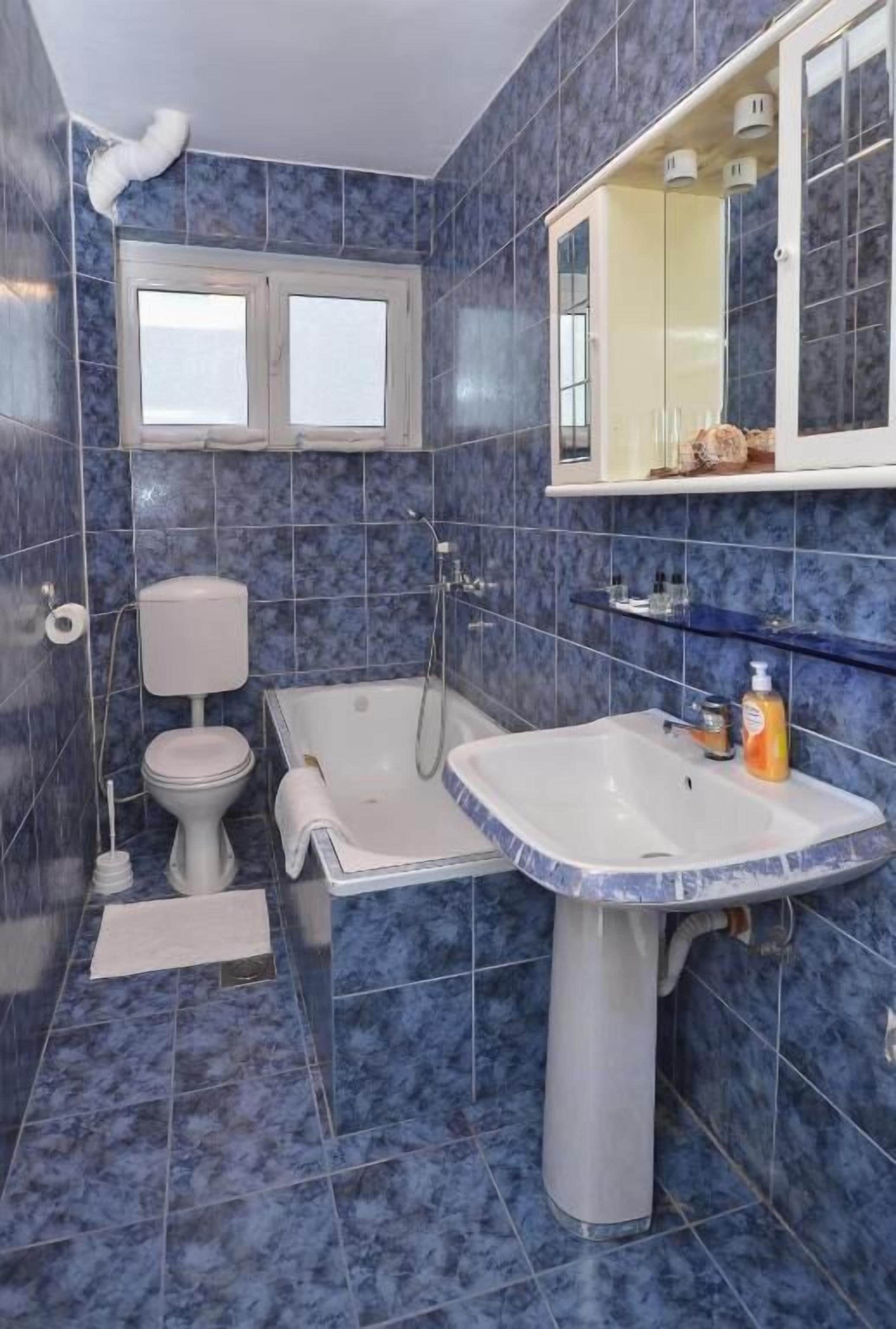 A bathroom with a bathtub, toilet, and sink.