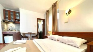 A hotel room with a bed, a desk, and a kitchenette. - Apartments Petkovic Budva (Budva)