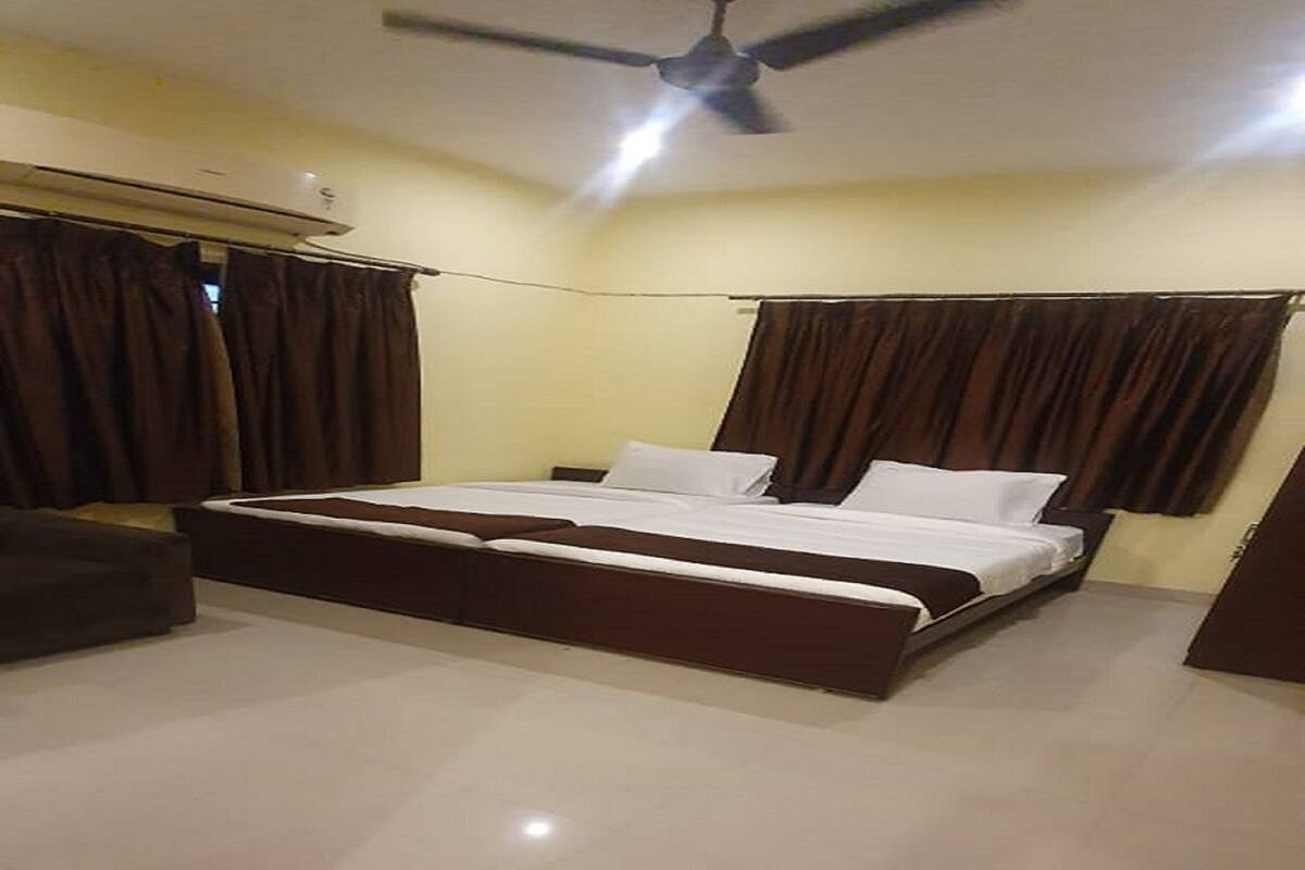 A bedroom with a bed, curtains, a ceiling fan, and a tiled floor.