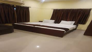 A bedroom with a bed, curtains, a ceiling fan, and a tiled floor.