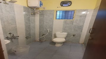 A small bathroom with a toilet, sink, and shower.