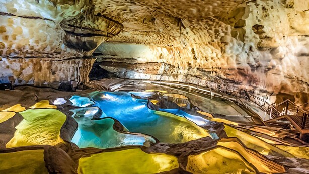 Une grotte dotée d’une piscine naturelle et d’un plafond rocheux.