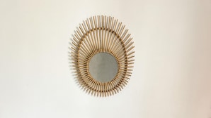A rustic wooden table with a unique carved chair leg and a decorative mirror with a bamboo frame on the wall. - Mambo Cabana (Pwani Mchangani)