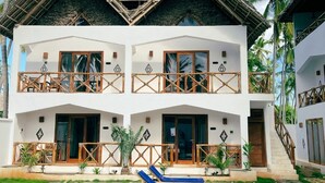 A two-story building with a pool, surrounded by palm trees. - Mambo Cabana (Pwani Mchangani)