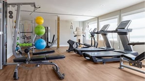 A gym with treadmills, a bench press, and exercise balls.
