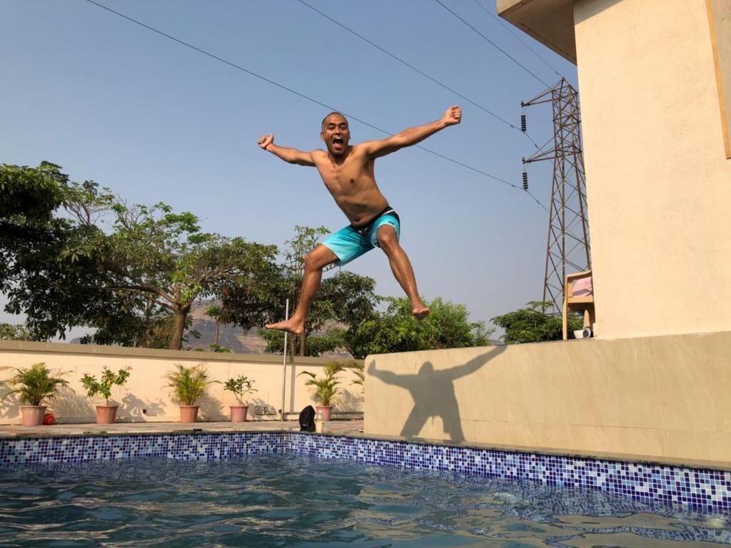 A person jumping into a swimming pool from a high platform.