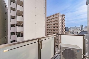 A high-rise building with multiple balconies and a clear sky. - Apartment Hotel 11 Namba Minami 7 (Osaka)