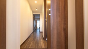 A hallway with wooden flooring and a marble floor transition. - The Premium Namba Minami  (Osaka)