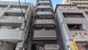 A multi-story building with balconies, a visible entrance, and signage indicating a business or service establishment. - The Premium Namba Minami  (Osaka)