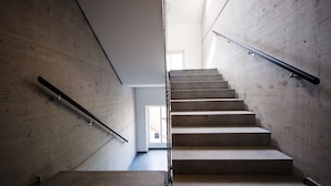 A staircase with a handrail, leading to an upper floor.
