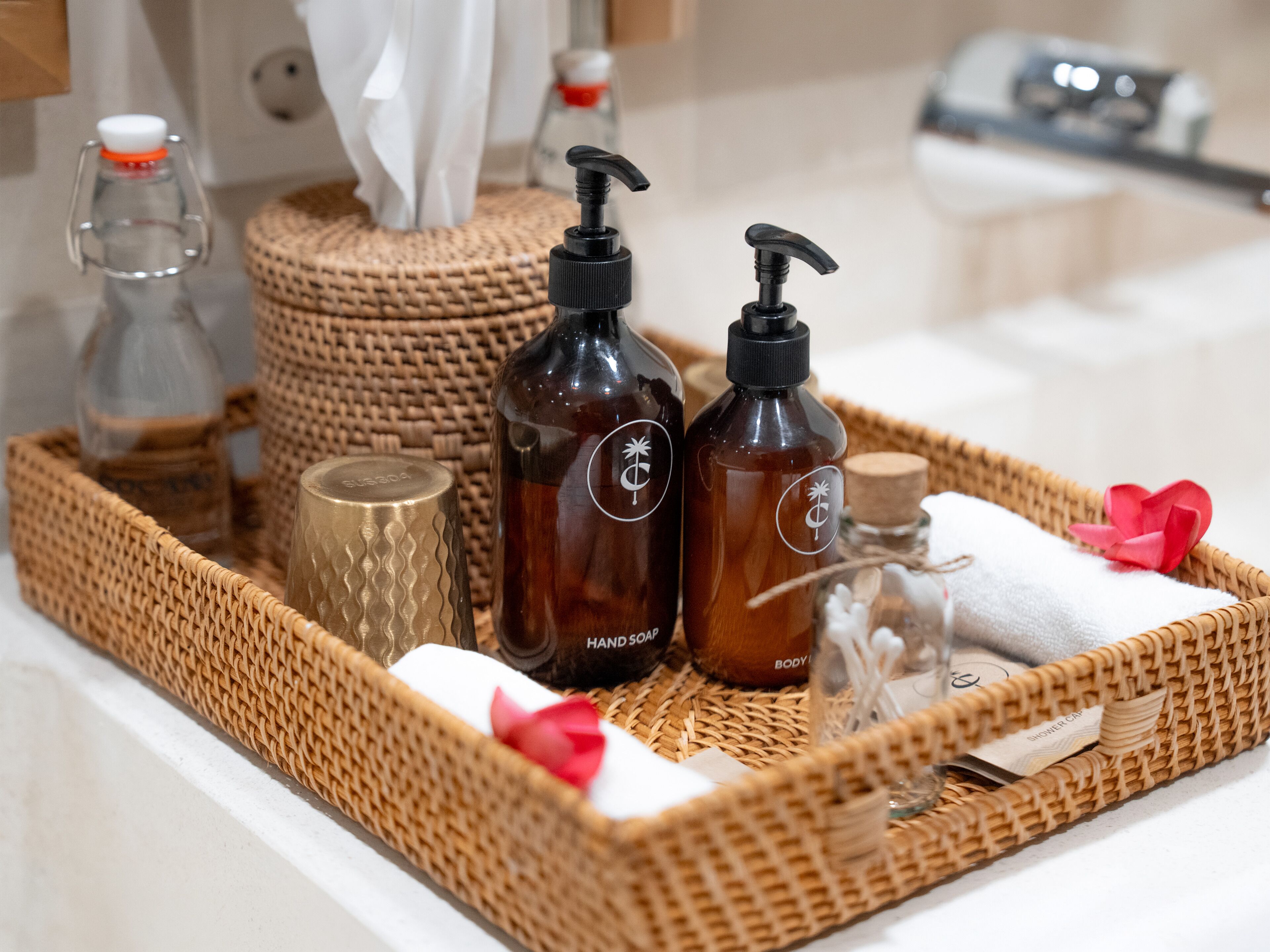 A tray with toiletries including hand soap, body wash, and a shower cap.