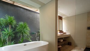 A modern bathroom with a freestanding bathtub, a large mirror, and a shower area. - Cocana Resort Gili Trawangan (Gili Trawangan)