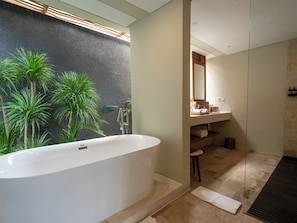 Un baño moderno con una bañera independiente, un espejo grande y una zona de ducha.