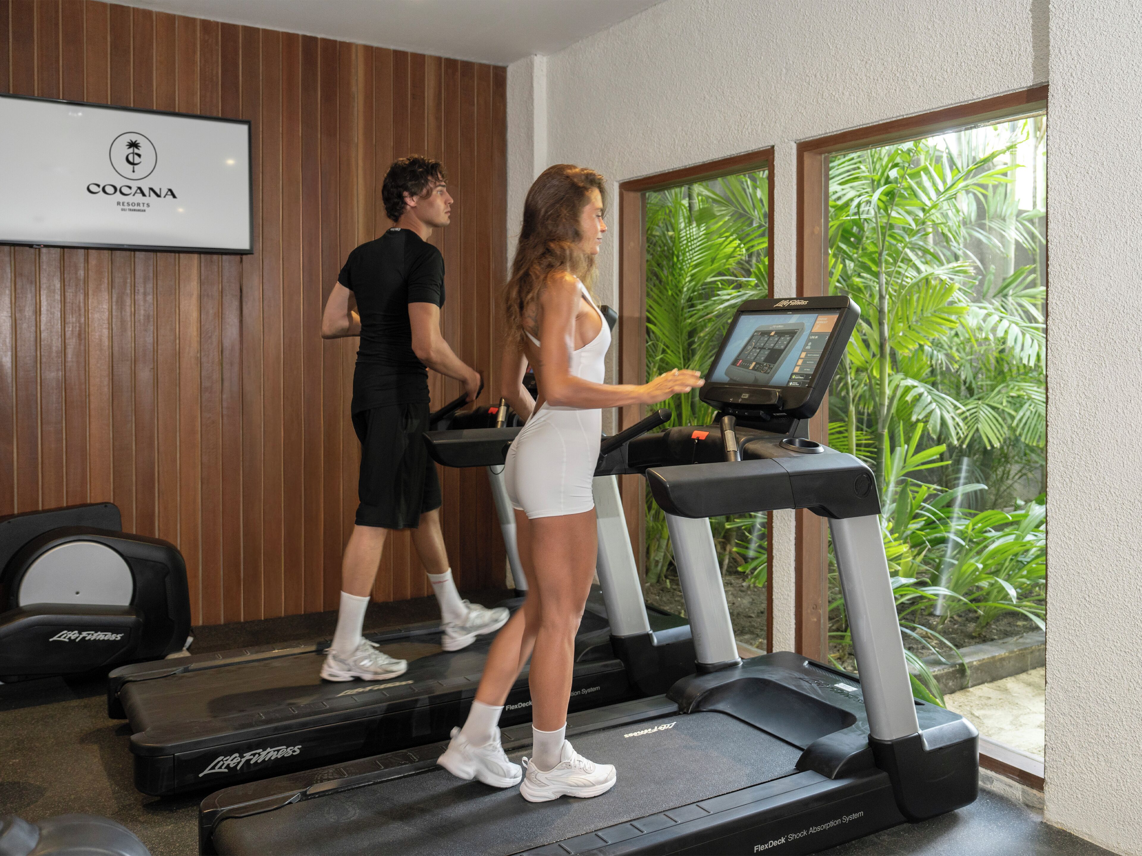 A fitness area with treadmills, a Life Fitness bench, and a FlexDeck Shock Absorption System.