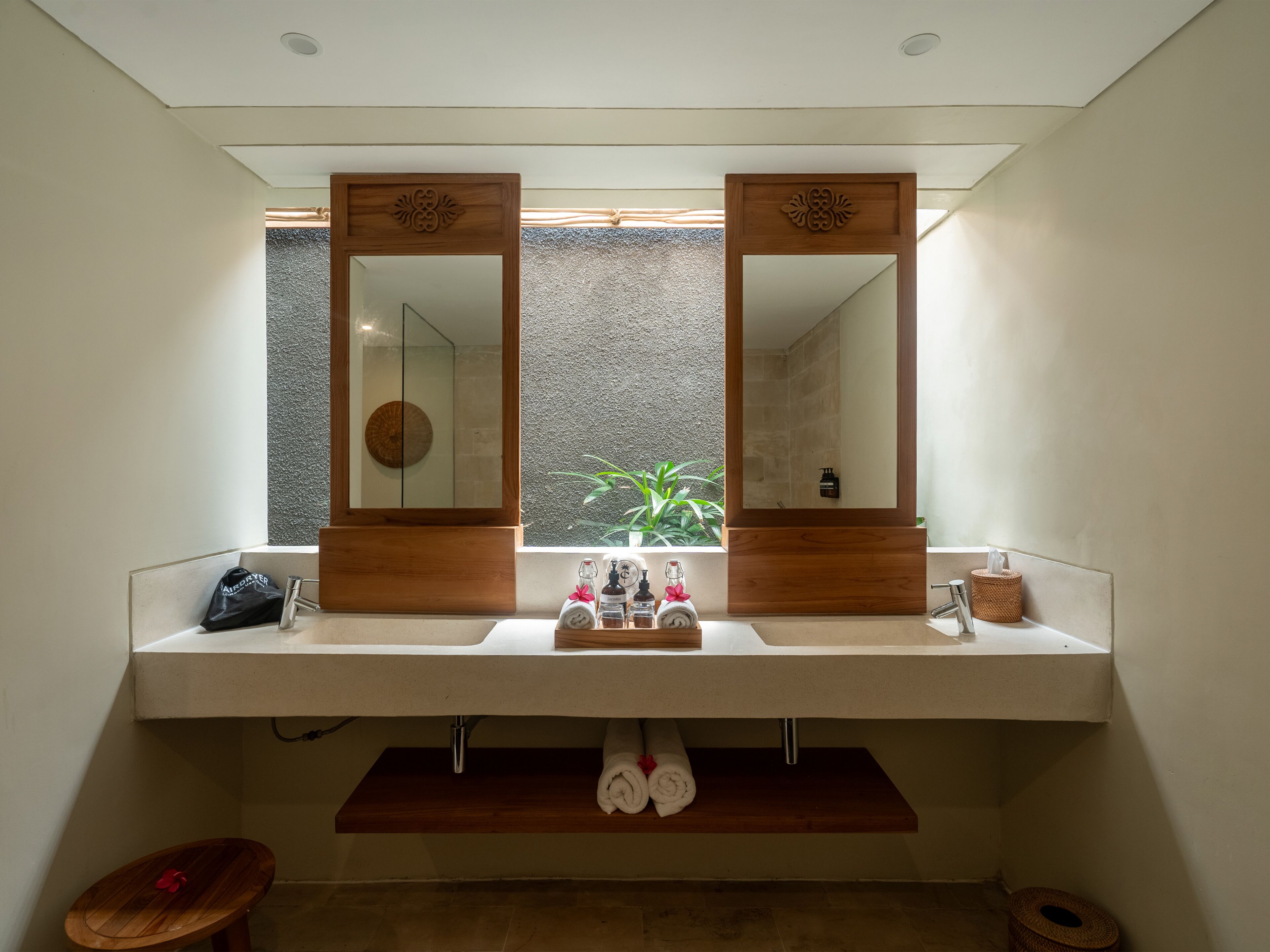 A bathroom with a double sink, wooden vanity, and a large mirror.