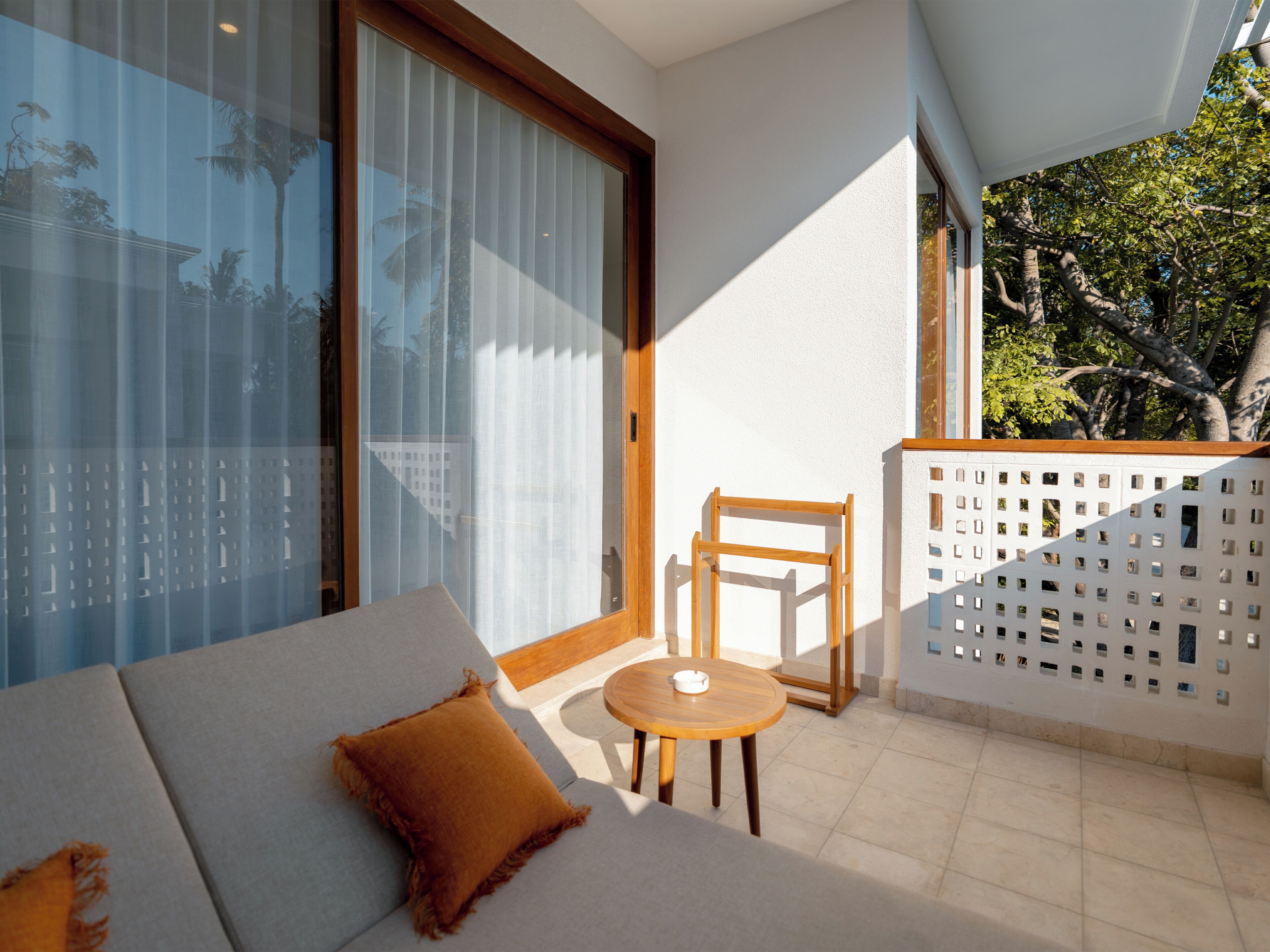 Een balkon met een bank, een tafeltje en een stoel.