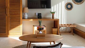 Uma sala de estar moderna com uma mesa de madeira, um sofá, uma TV e um telefone fixado na parede.